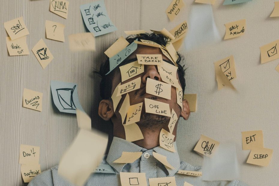 Man on a room corner covered in sticky notes